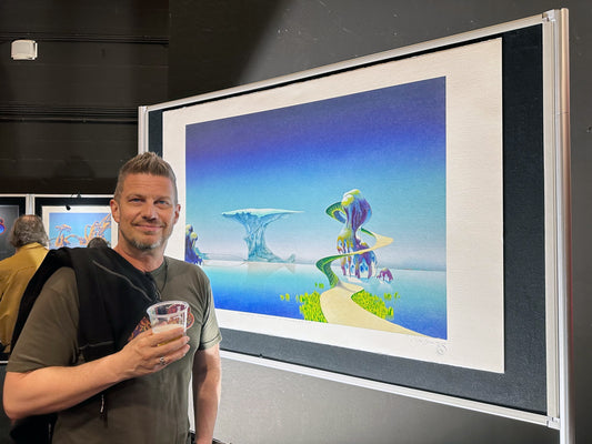 ROSSI steht vor einem Bild des Künstlers Roger Dean, der die Plattencover der Rockband YES gestaltet.